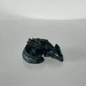 Figurină dragon verde pe masă albă.