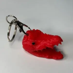 Breloc cap de crocodil roșu din plastic